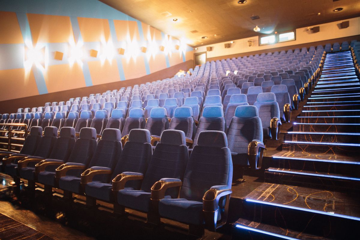 Empty cinema auditorium with rows of blue seats